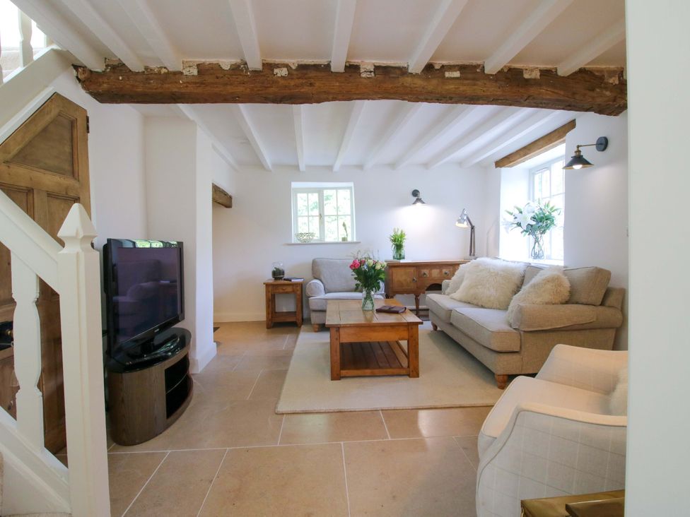 A living room with a sofa and television at 5 Shrewsbury Road in Much Wenlock