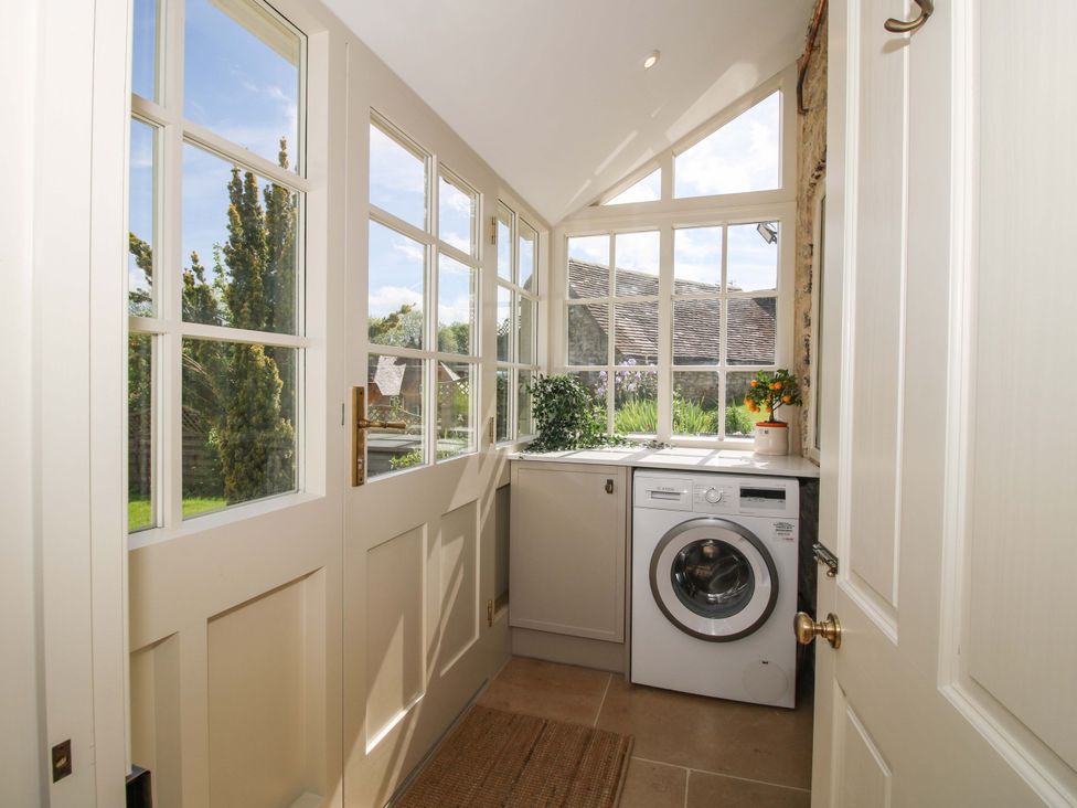 A utility room with a washing machine and windows at 5 Shrewsbury Road Much Wenlock