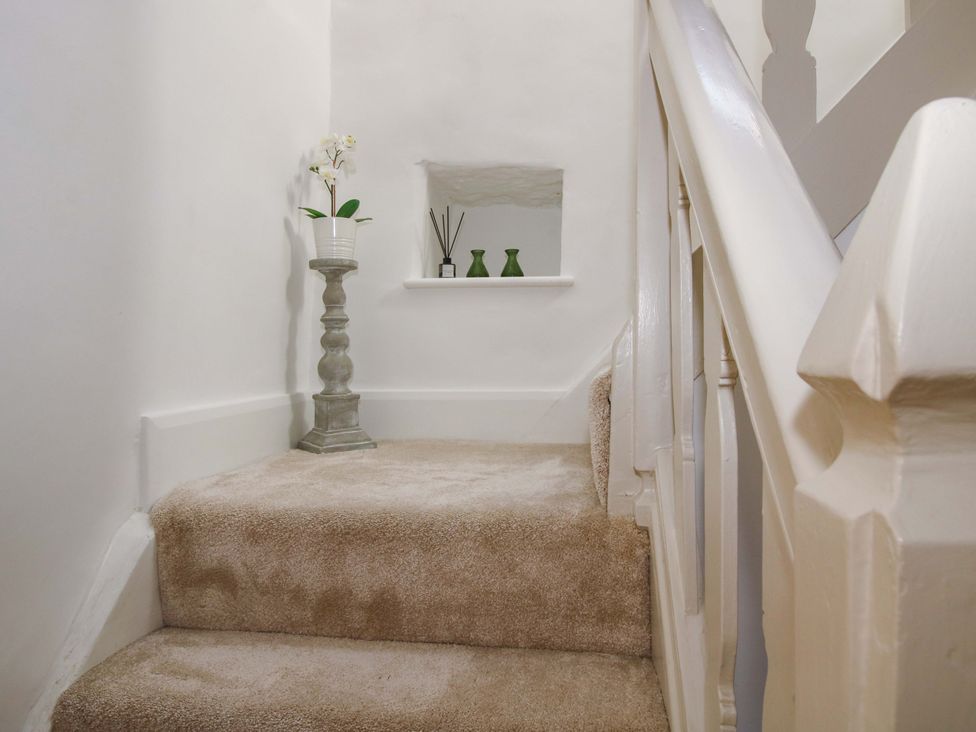 A staircase with carpet and decorative items at 5 Shrewsbury Road in Much Wenlock