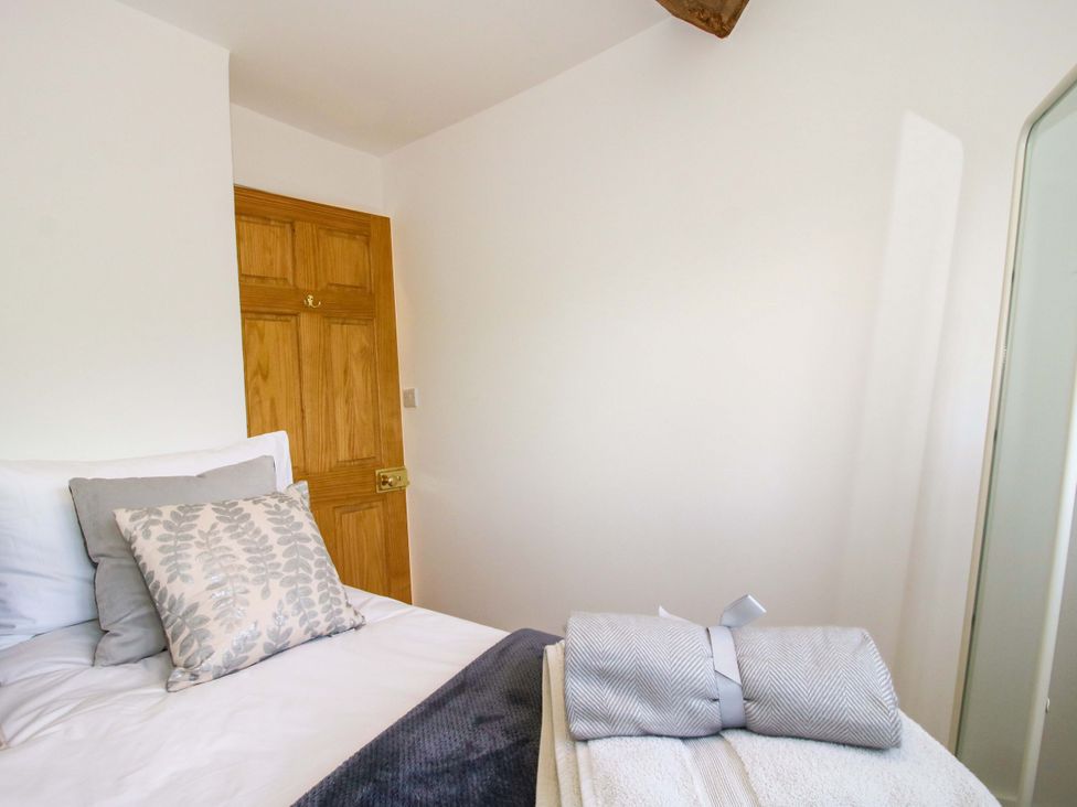 A bedroom with a bed and towels at 5 Shrewsbury Road in Much Wenlock