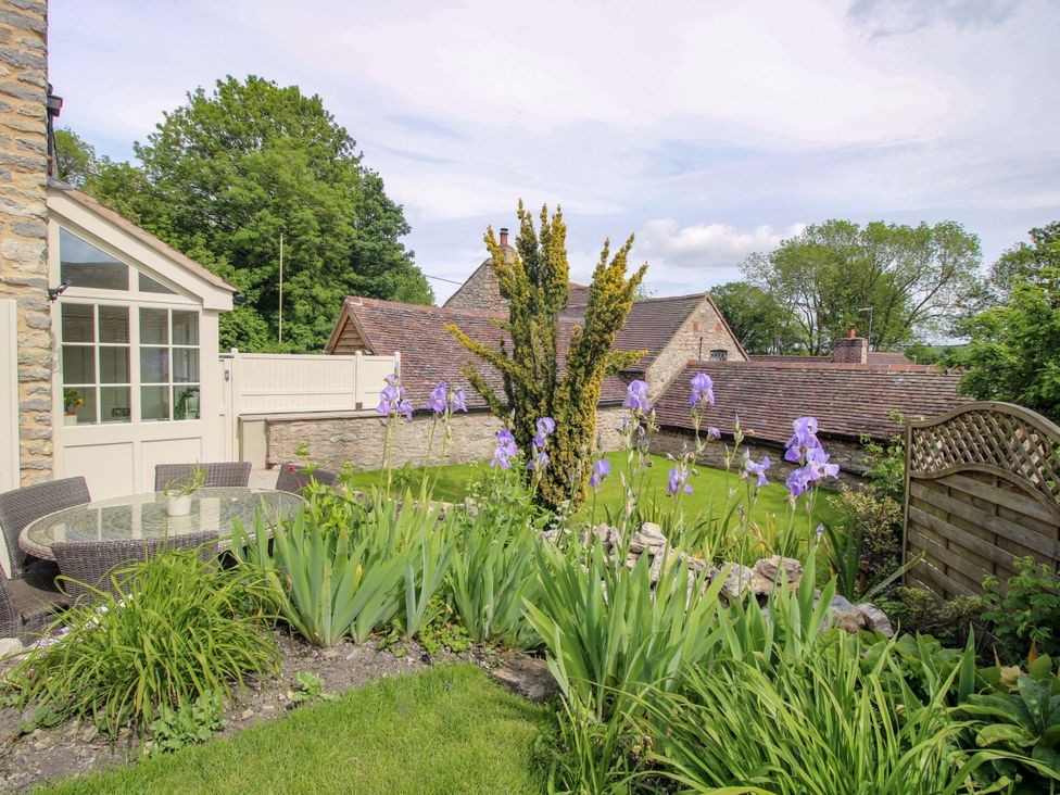 A garden with flowers and a seating area at 5 Shrewsbury Road Much Wenlock