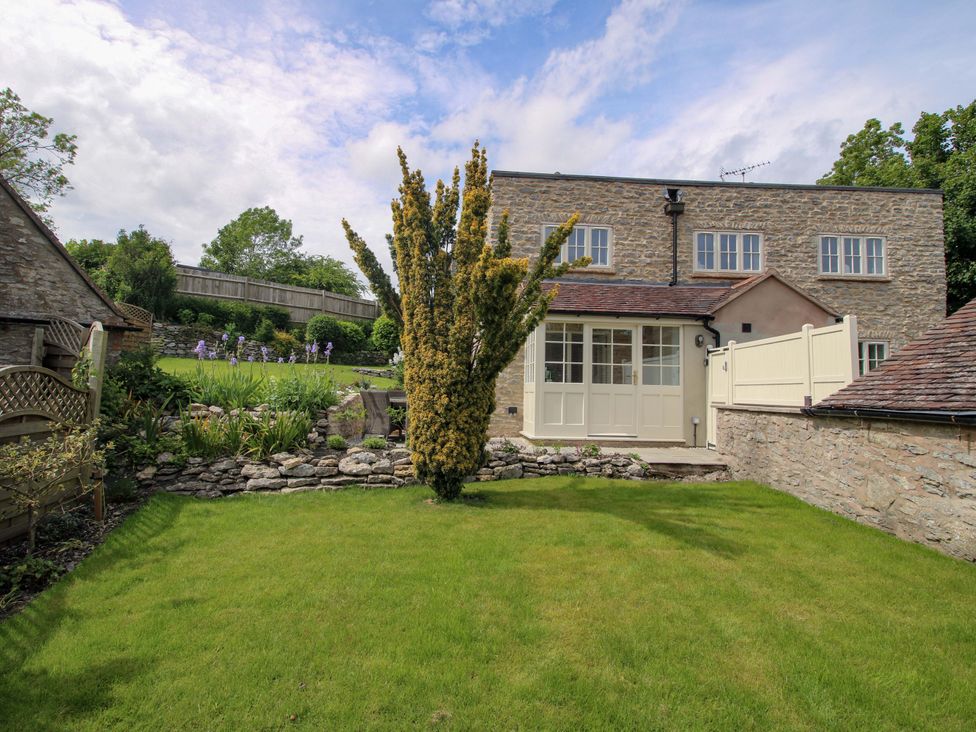 An outdoor area with a garden and stone wall at 5 Shrewsbury Road in Much Wenlock