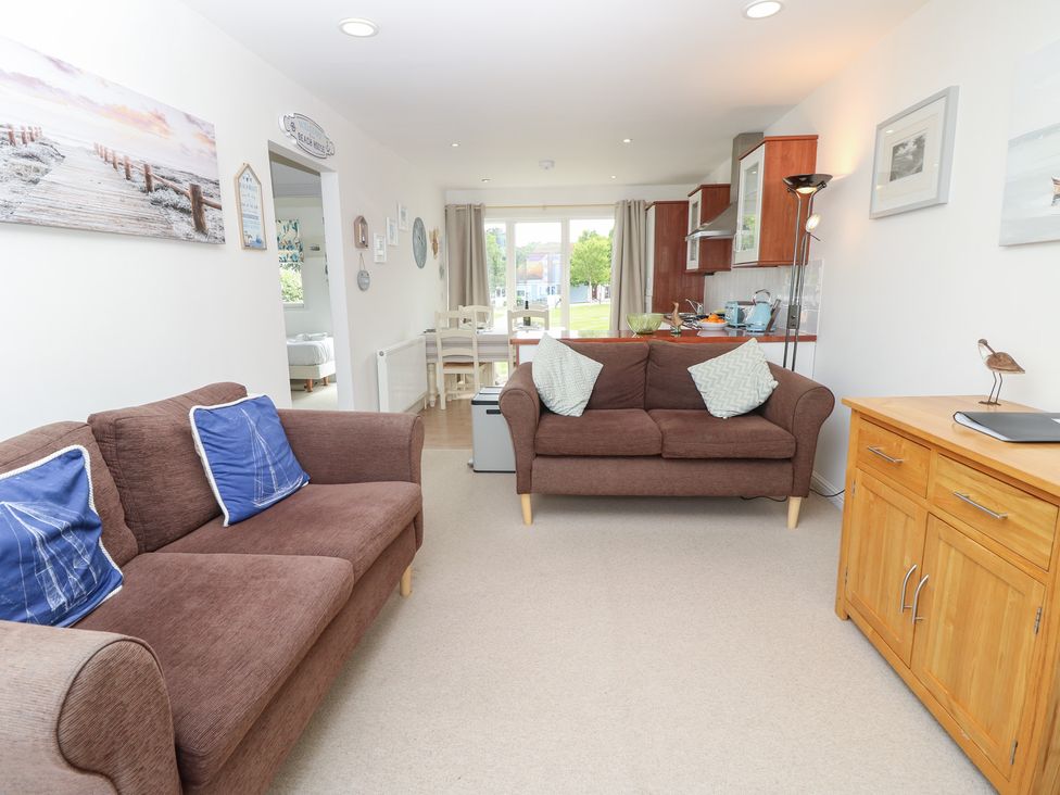 A living room with sofas and a kitchen area at Plimoth N8 Yarmouth