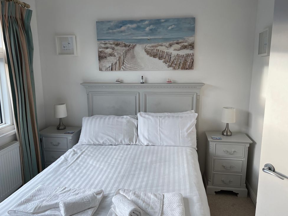 A bedroom with a bed and bedside tables at Plimoth N8 in Yarmouth