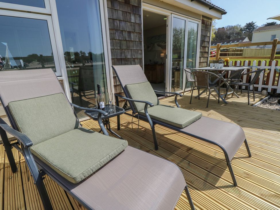 An outdoor area with sun loungers and a dining table at Plimoth N8 Yarmouth