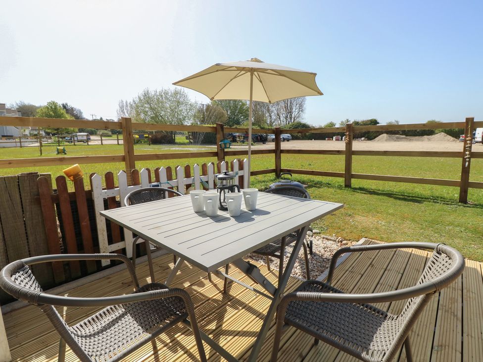 A table with chairs and an umbrella at Plimoth N8 in Yarmouth