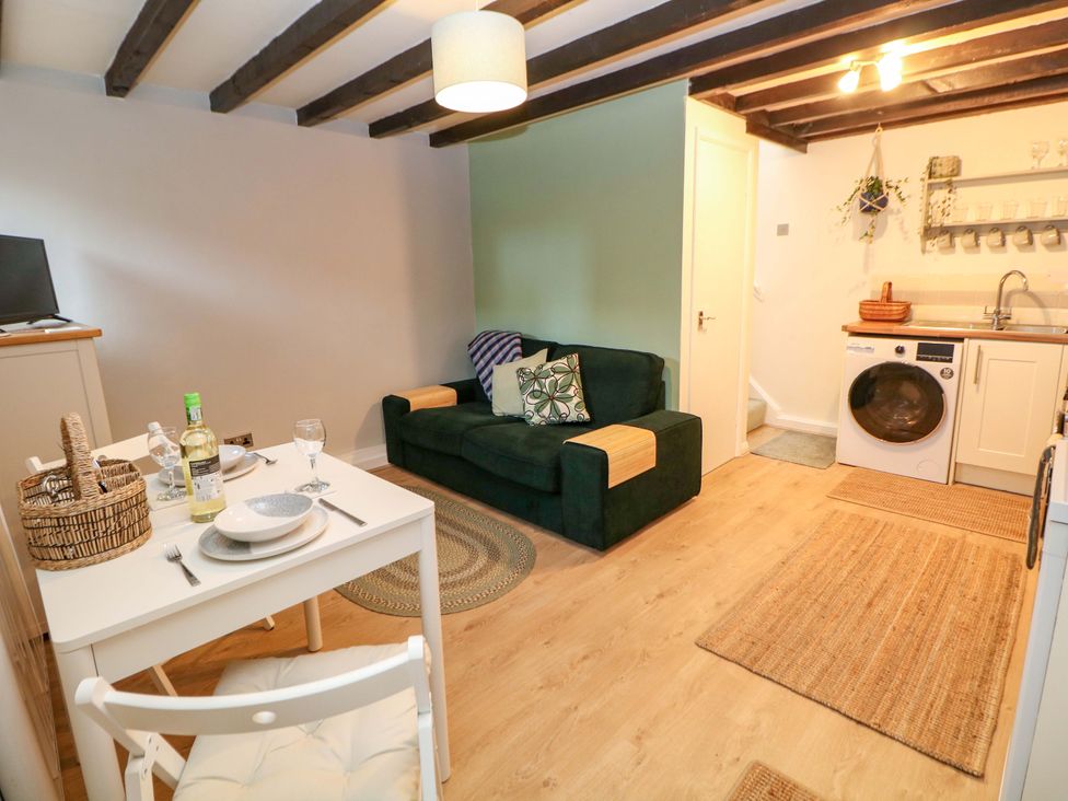 A living room with a sofa and dining table at Little Thornsett