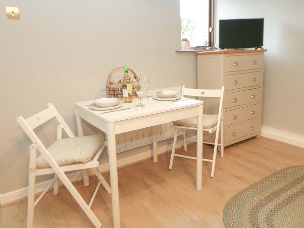 A dining table with chairs and a dresser at Little Thornsett