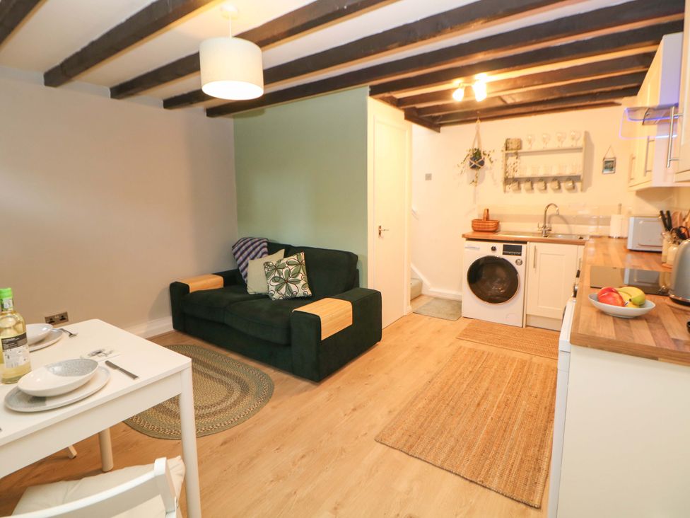 A living room with a sofa, dining table and kitchen area at Little Thornsett