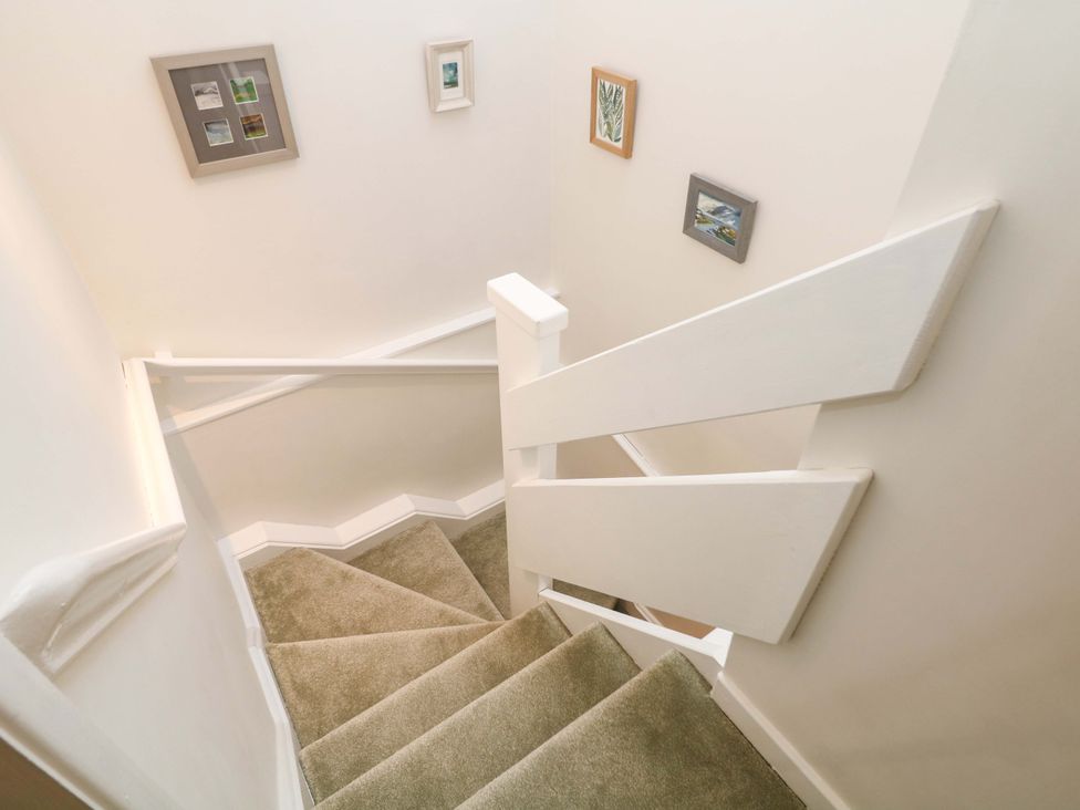 A staircase with pictures on the wall at Little Thornsett