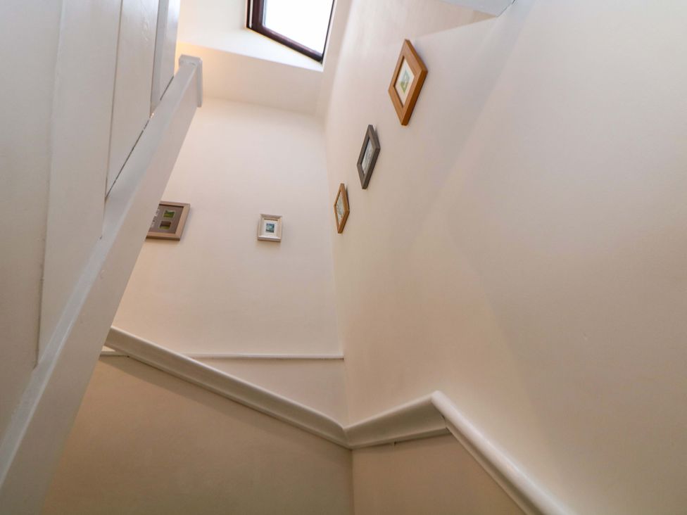 A staircase with pictures on the wall at Little Thornsett