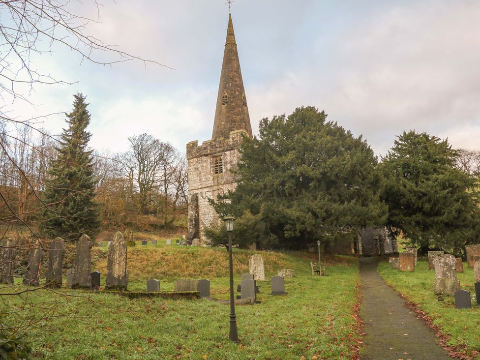 A church with gravestones and trees in the foreground at Little Thornsett