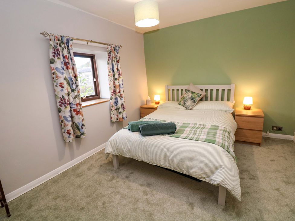 A bedroom with a bed and bedside tables at Little Thornsett