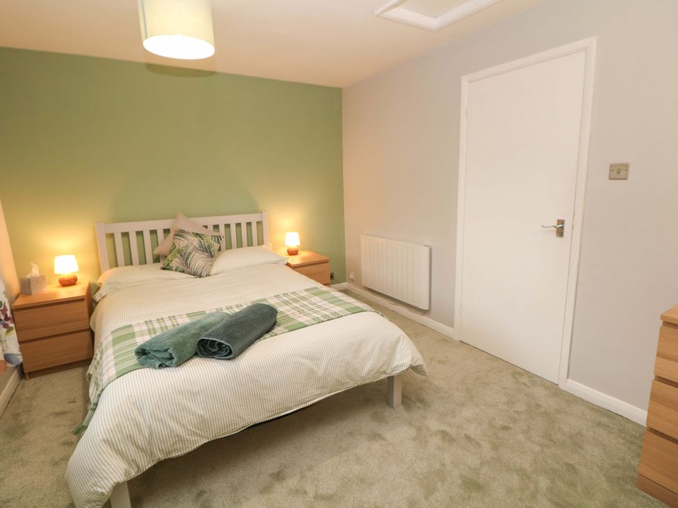 A bedroom with a bed and bedside lamps at Little Thornsett