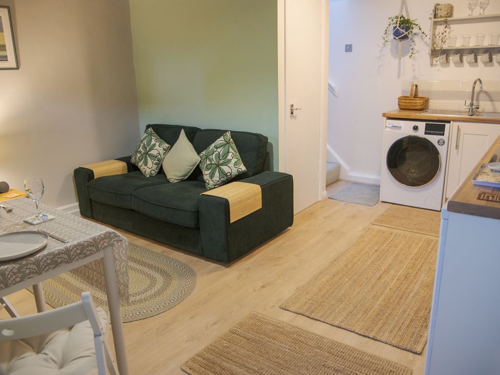 A living room with a sofa and dining table at Little Thornsett in Chelmorton