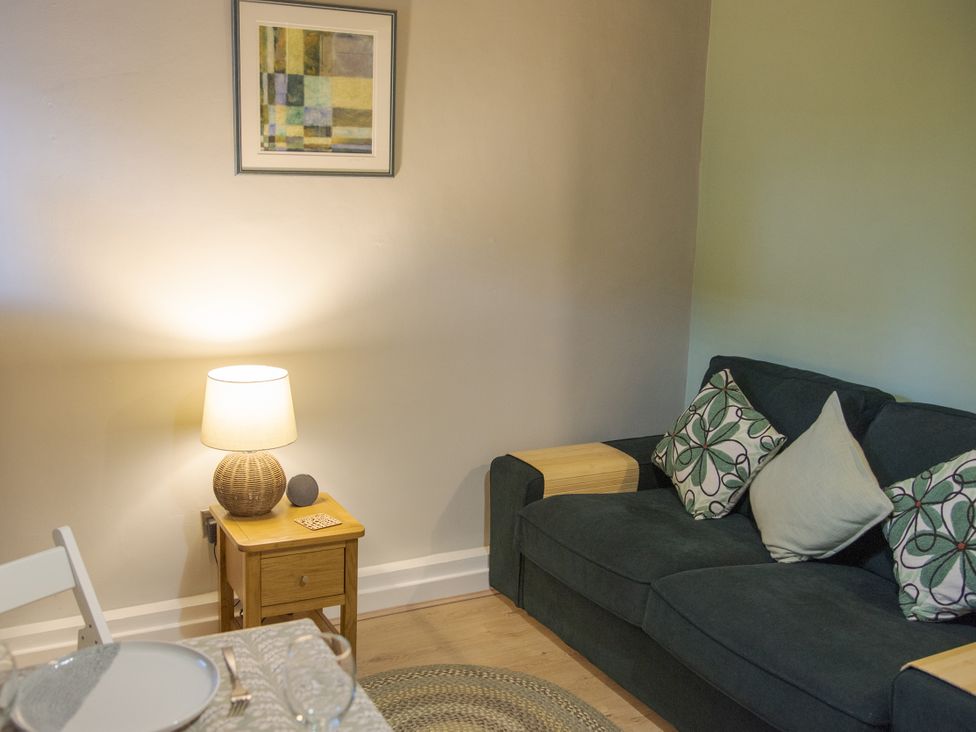 A living room with a sofa and a lamp at Little Thornsett Chelmorton