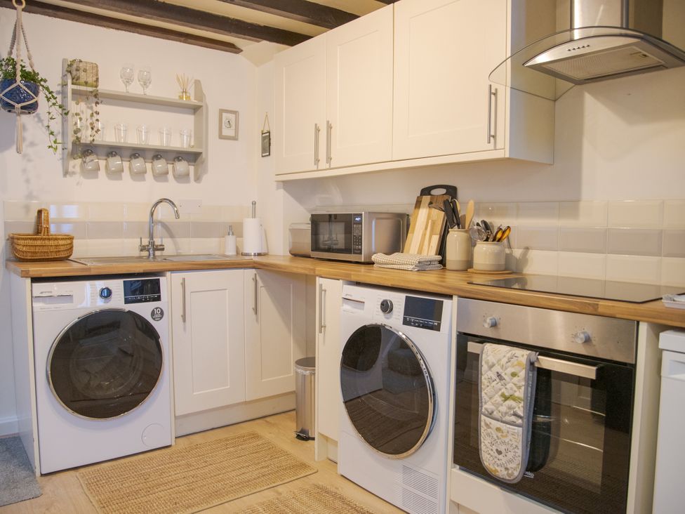 A kitchen with washing machine and microwave at Little Thornsett in Chelmorton