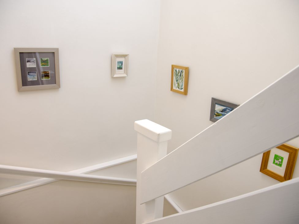 A staircase with picture frames on the wall at Little Thornsett in Chelmorton
