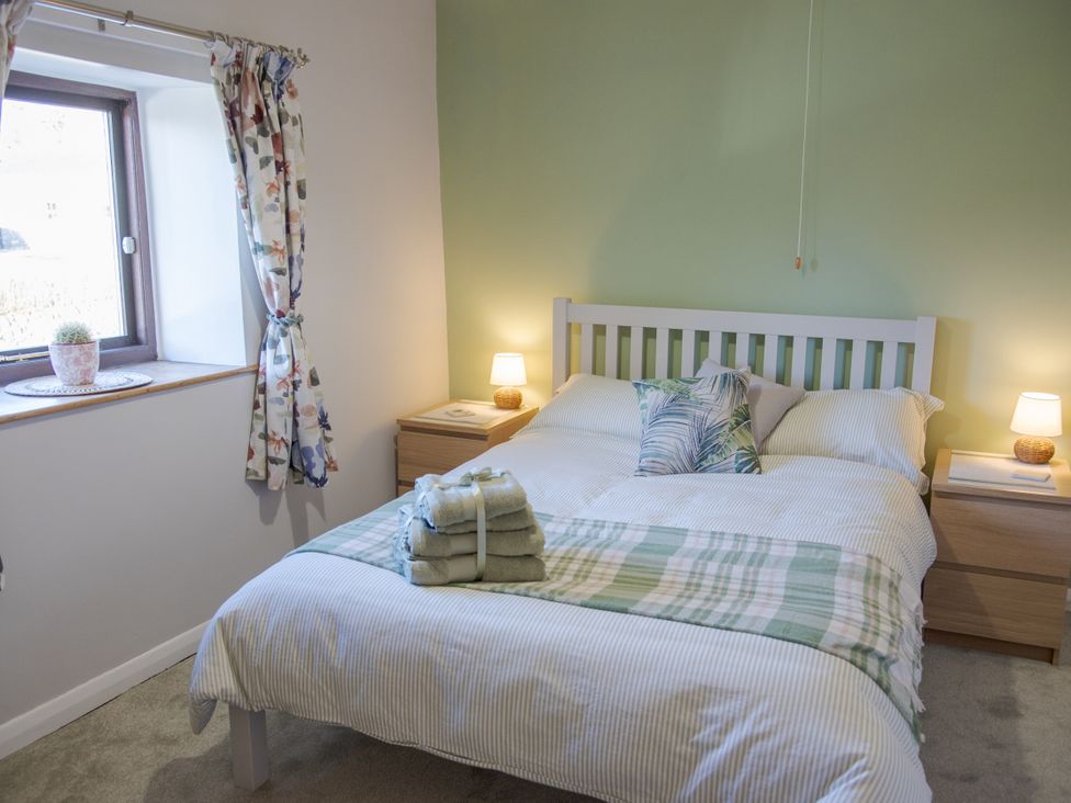 A bedroom with a bed and bedside tables at Little Thornsett Chelmorton