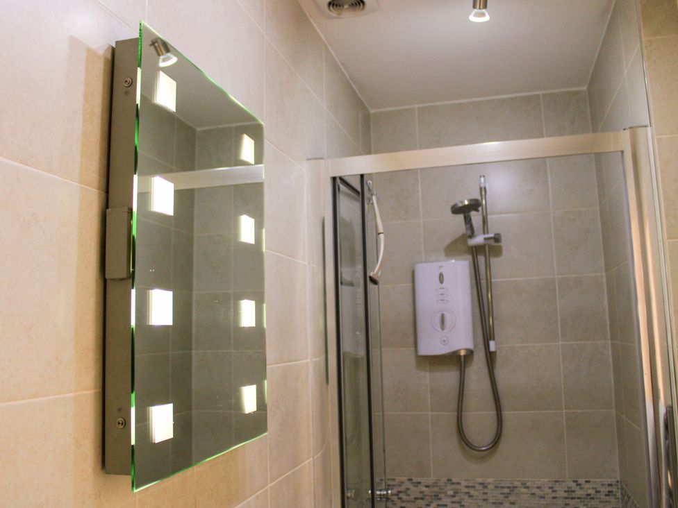 A bathroom with a shower and a mirror at 2 The Elms in Salcombe
