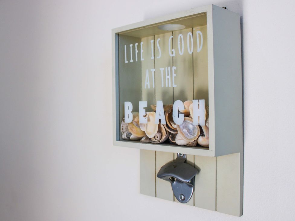 A wall decoration with seashells and a bottle opener at 2 The Elms Salcombe
