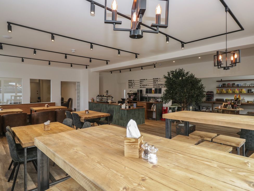 A café interior with wooden tables and a counter at Elter Luxury Pod in Keswick