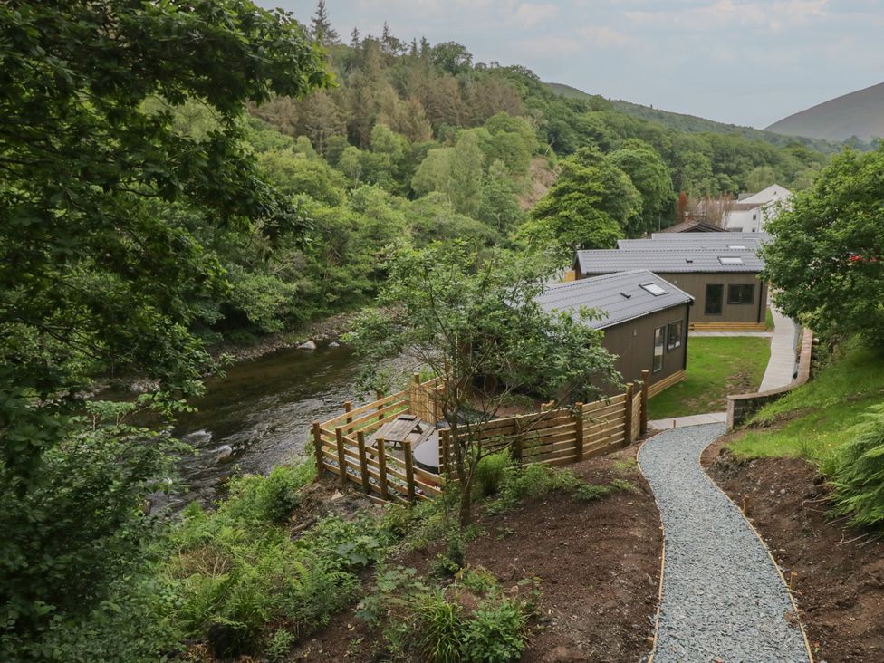 An outdoor area with a river and buildings at Hodge Luxury Pod in Keswick