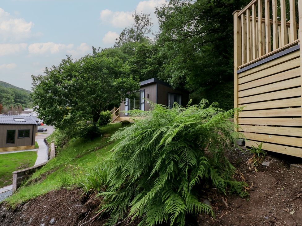 An outdoor area with a pod, decking, and greenery at Hodge Luxury Pod in Keswick
