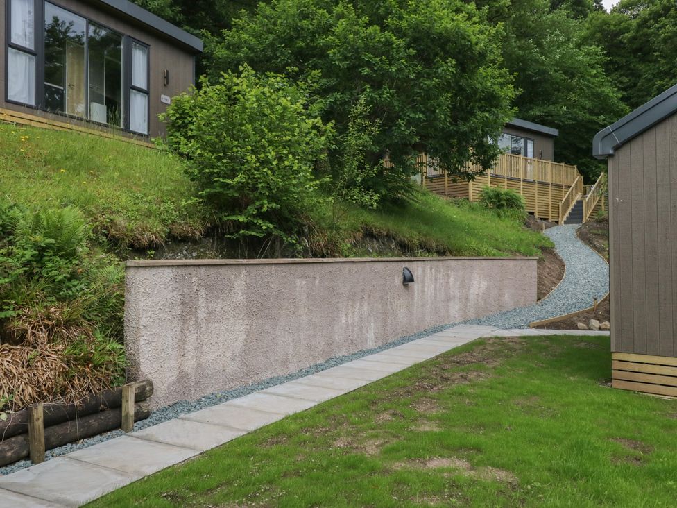 An outdoor area with a pathway leading to lodges with greenery at Hodge Luxury Pod in Keswick