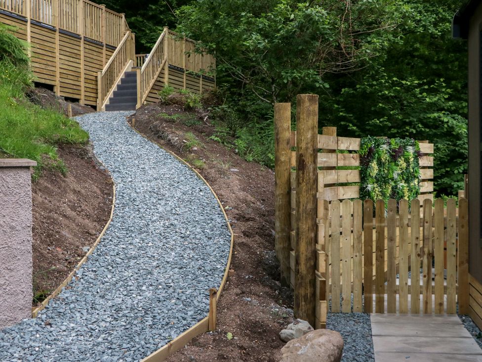 A gravel pathway leading to a wooden gate at Dubs Luxury Family Pod in Keswick