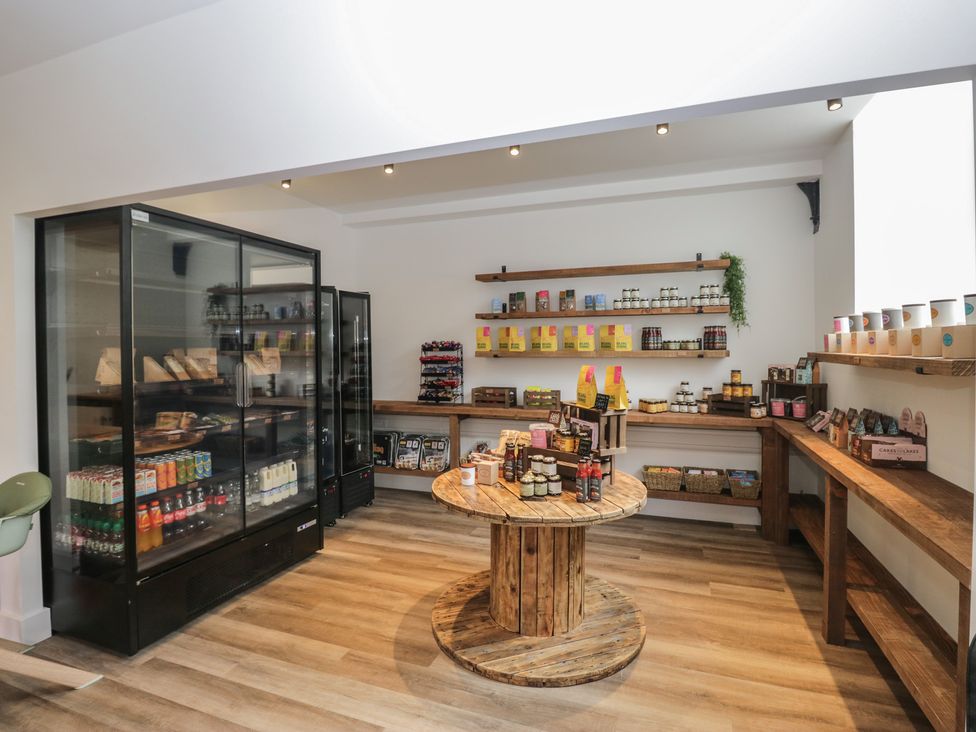 A store with shelves and a wooden table at Dubs Luxury Family Pod in Keswick