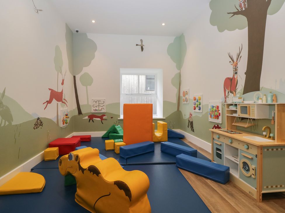 A playroom with foam blocks and a play kitchen at Sail Luxury Family Pod in Keswick