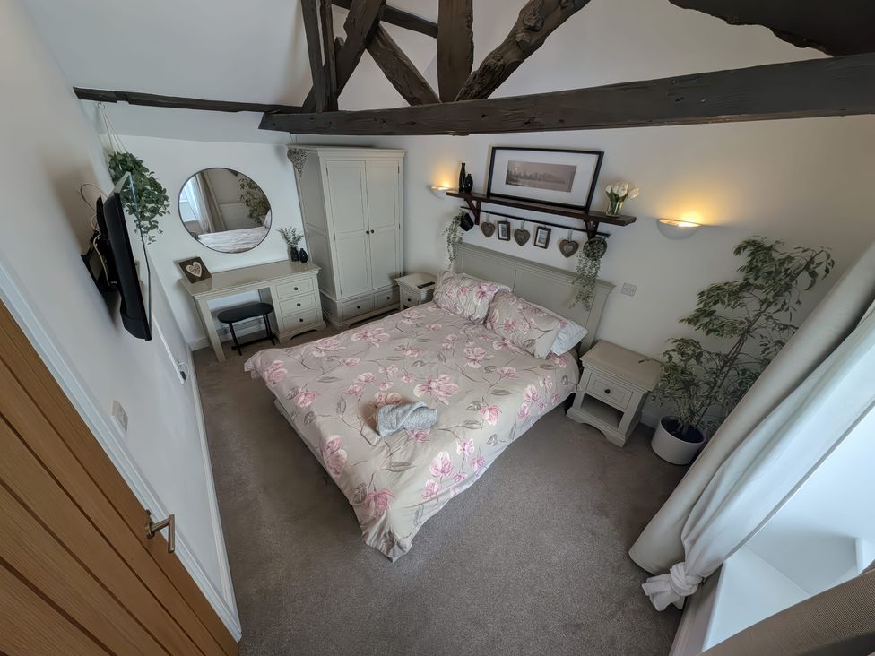 A bedroom with a bed and desk at Hocking Cottage in St Marychurch