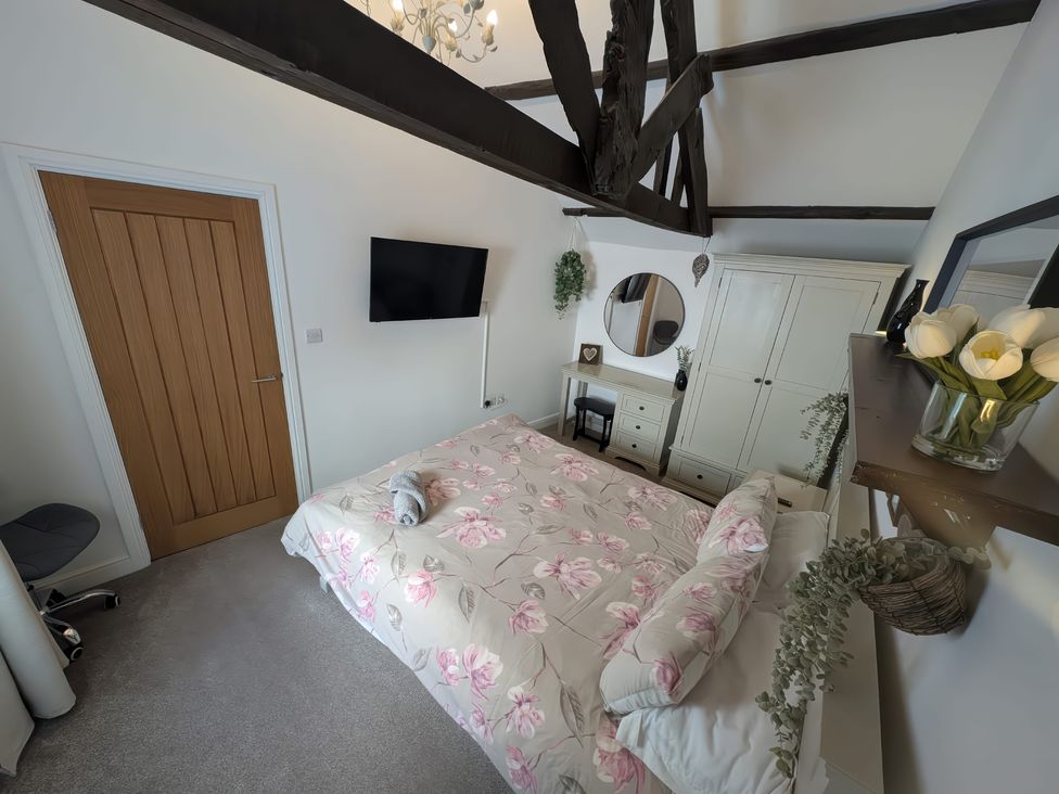 A bedroom with a bed and wardrobe at Hocking Cottage St Marychurch