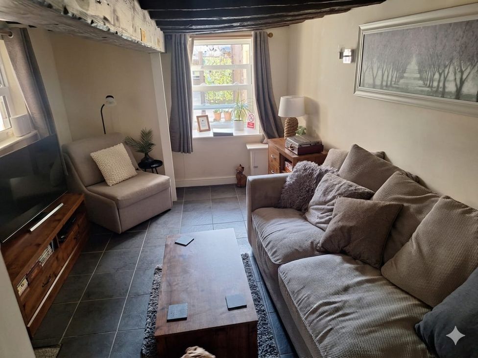 A living room with a sofa and coffee table at Hocking Cottage in St Marychurch