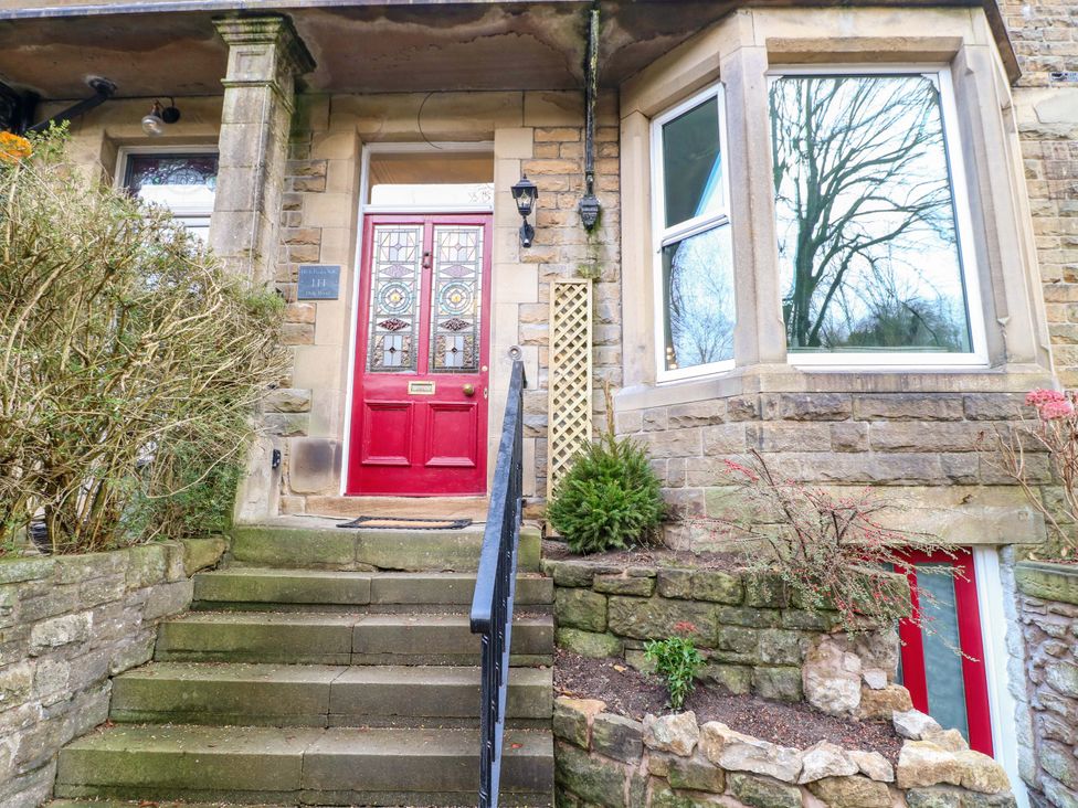 A front entrance with a red door and stone steps at High Peaks Villa in Buxton