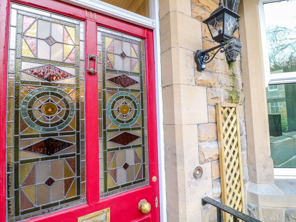 An entryway featuring a red front door with stained glass panels at High Peaks Villa in Buxton