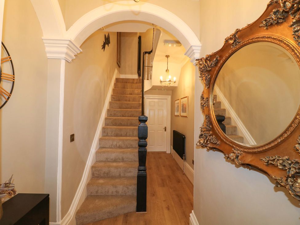 A staircase and a mirror in a hallway at High Peaks Villa in Buxton