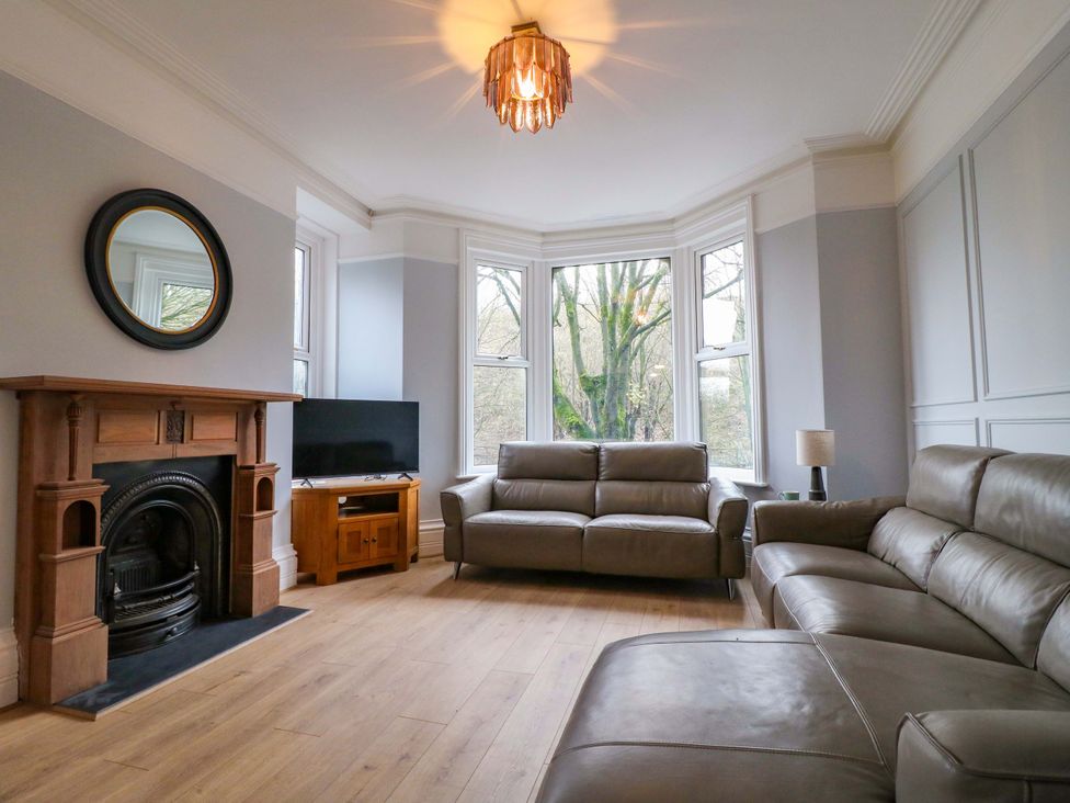 A living room with a sofa and television at High Peaks Villa in Buxton