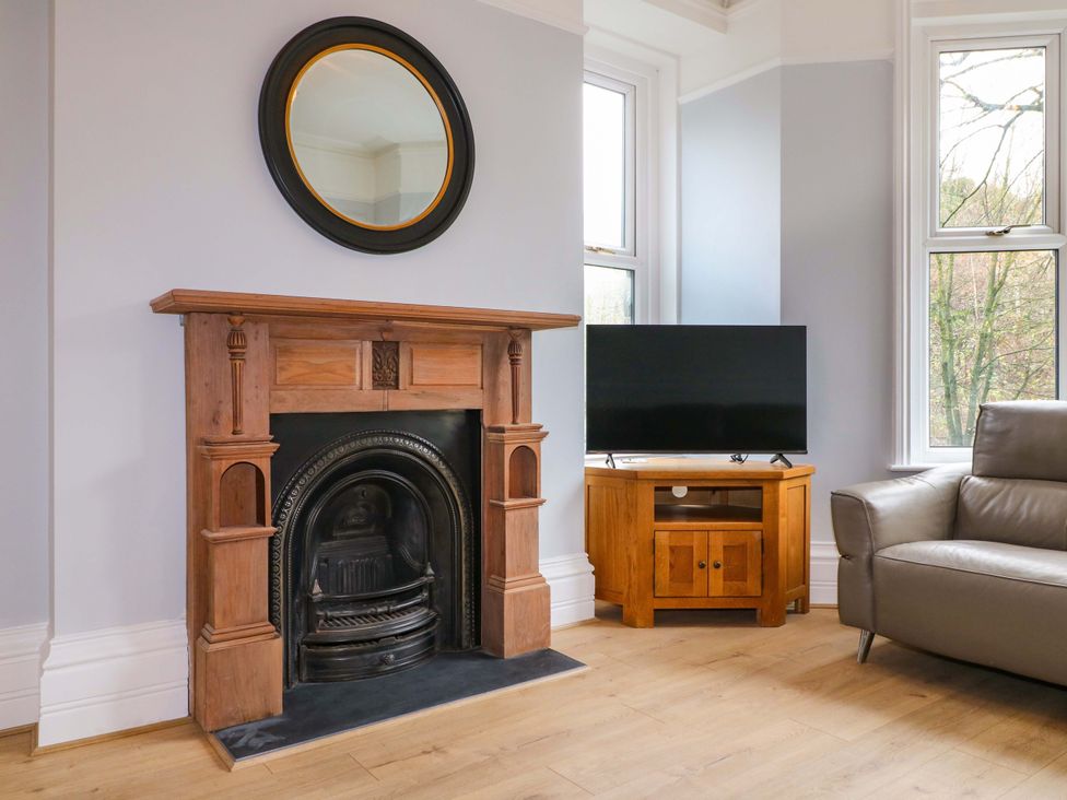 A living room featuring a fireplace and a television at High Peaks Villa in Buxton
