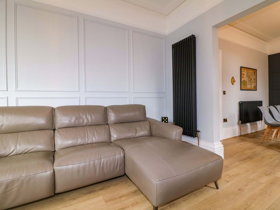 A living room with a sofa and a radiator at High Peaks Villa in Buxton