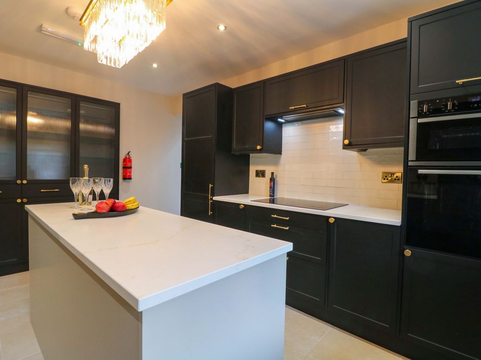 A kitchen with a central island and glassware at High Peaks Villa Buxton
