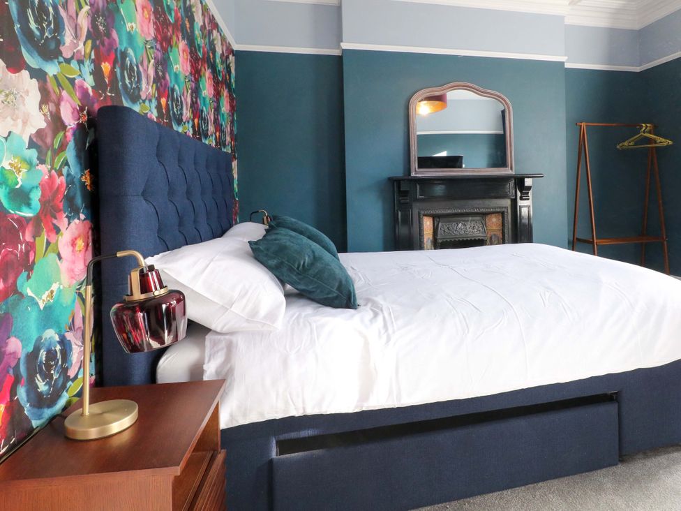 A bedroom with a bed and a lamp at High Peaks Villa in Buxton