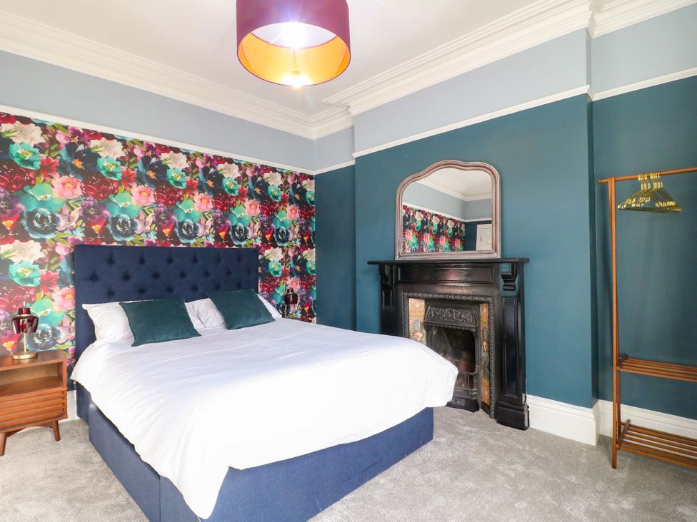 A bedroom with a bed and nightstand at High Peaks Villa in Buxton