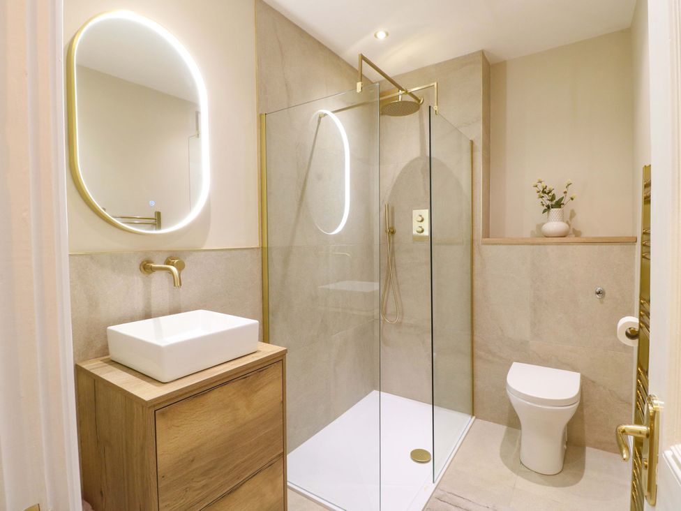 A bathroom with a shower, sink and toilet at High Peaks Villa in Buxton