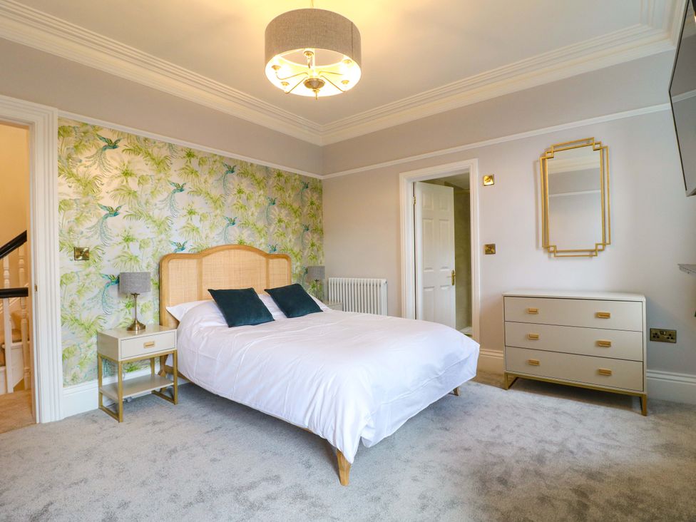A bedroom with a bed and dresser at High Peaks Villa in Buxton