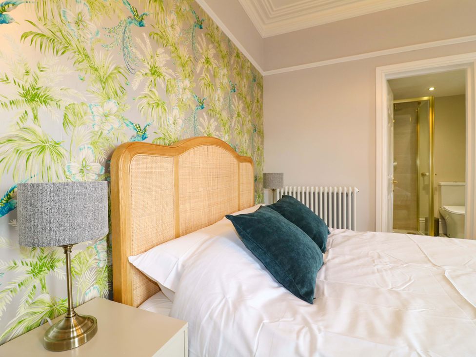A bedroom featuring a bed with pillows and lamp at High Peaks Villa in Buxton