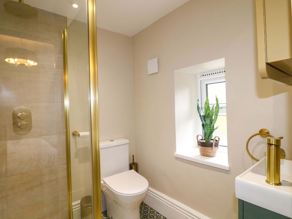 A bathroom with a shower, toilet, and sink at High Peaks Villa in Buxton