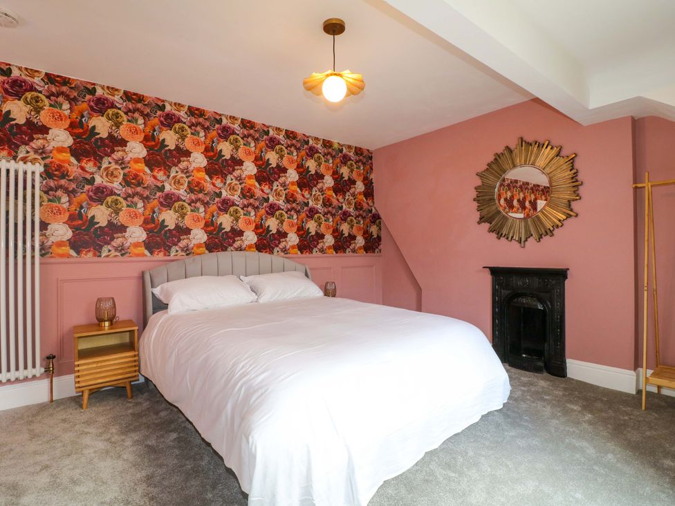 A bedroom with a bed and floral wallpaper at High Peaks Villa in Buxton