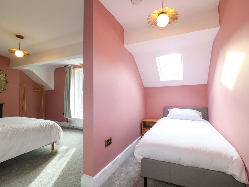 A bedroom with two beds and a window at High Peaks Villa Buxton